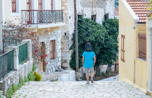 Fototapeta Naklejka Na Ścianę i Meble -  Man Carrying A Boy On His Shoulders Walking Down Kali Strata