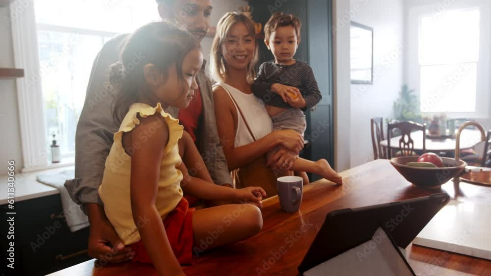 Family time with technology: Parents and kids video chat with their extended family on a tablet Family time with technology: Parents and kids video chat with their extended family on a tablet