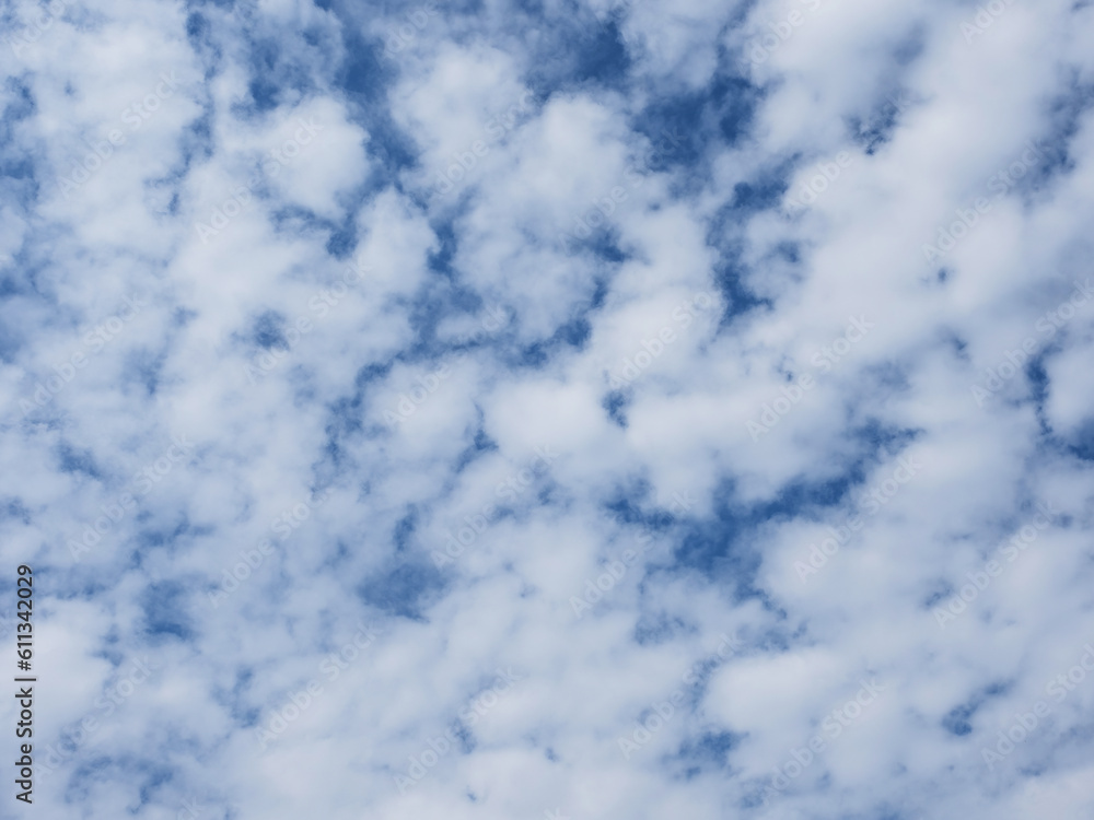 Obraz premium Blue sky with unusual fluffy abstract white clouds structure. Strange dramatic clouds pattern texture.