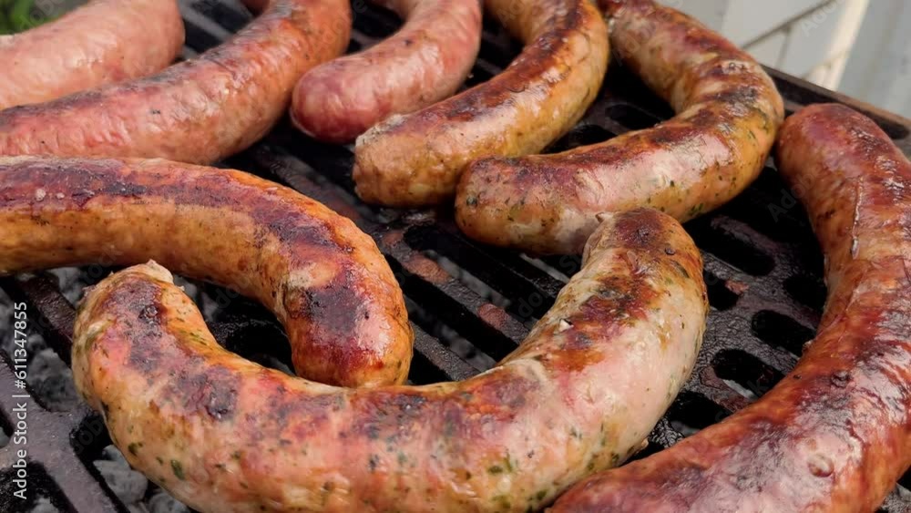Grilled sausages roasting on barbecue grill outdoors. BBQ. Grilled food fried and smoked in charcoal grills. Turns grill over with tasty delicious sausages. concept street food for picnic and camping Grilled sausages roasting on barbecue grill outdoors. BBQ. Grilled food fried and smoked in charcoal grills. Turns grill over with tasty delicious sausages. concept street food for picnic and camping