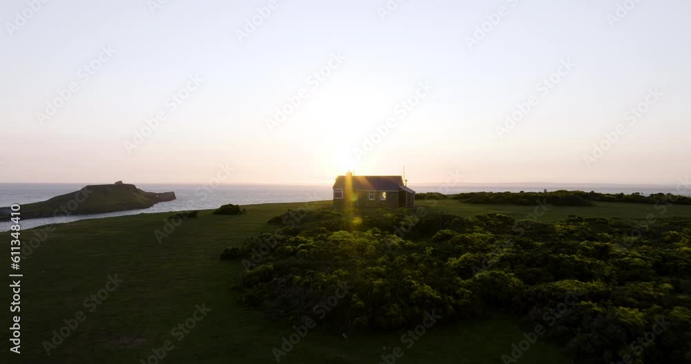 Coast Guard Hut On A Spectacular Coast Cliffside Back Lit By Setting Sun Coast Guard Hut On A Spectacular Coast Cliffside Back Lit By Setting Sun