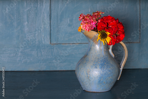 Blumenstrauß in getöpfertem Krug auf Bauernschrank Anrichte photo