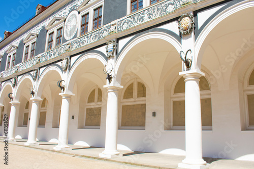 View of the white facade of the building with arches  columns  sculptures of animal heads  decorative elements and paintings. Enfilade. Sunny day with blue sky. Dresden  Germany  May 2023