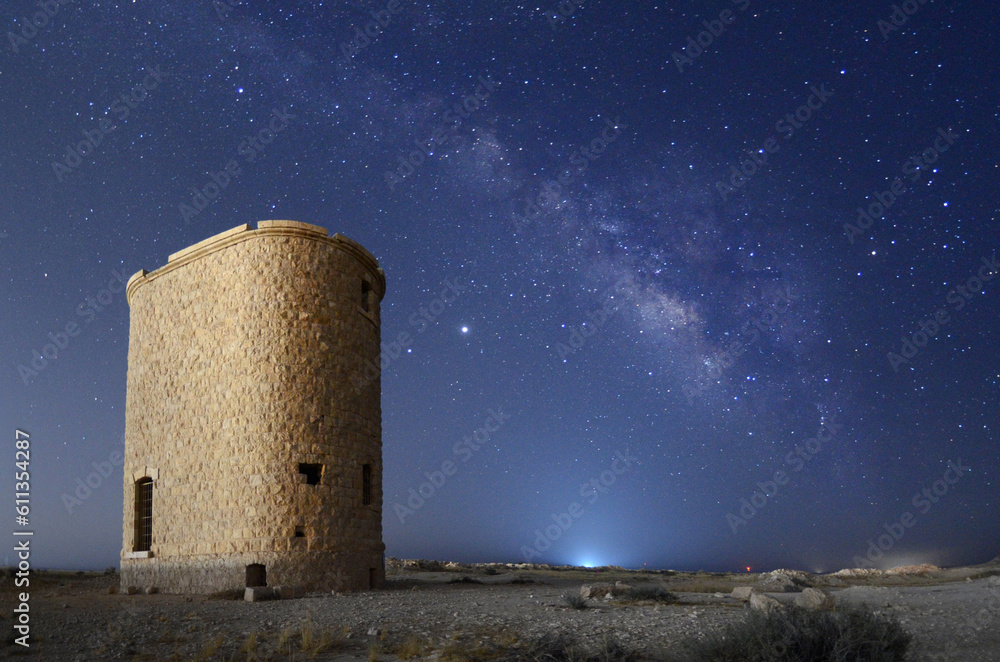 an abandon Ottoman train's station water tower in the middle of the desert and the milky way in the background 