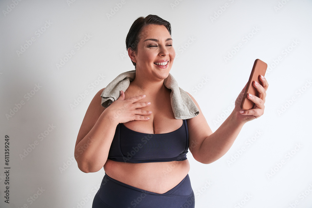 Happy plus size woman holding smartphone and enjoying video call isolated Happy plus size woman holding smartphone and enjoying video call isolated