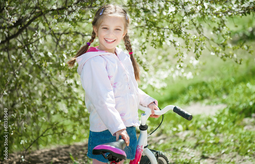 portrait of cute little girl on a bicycle