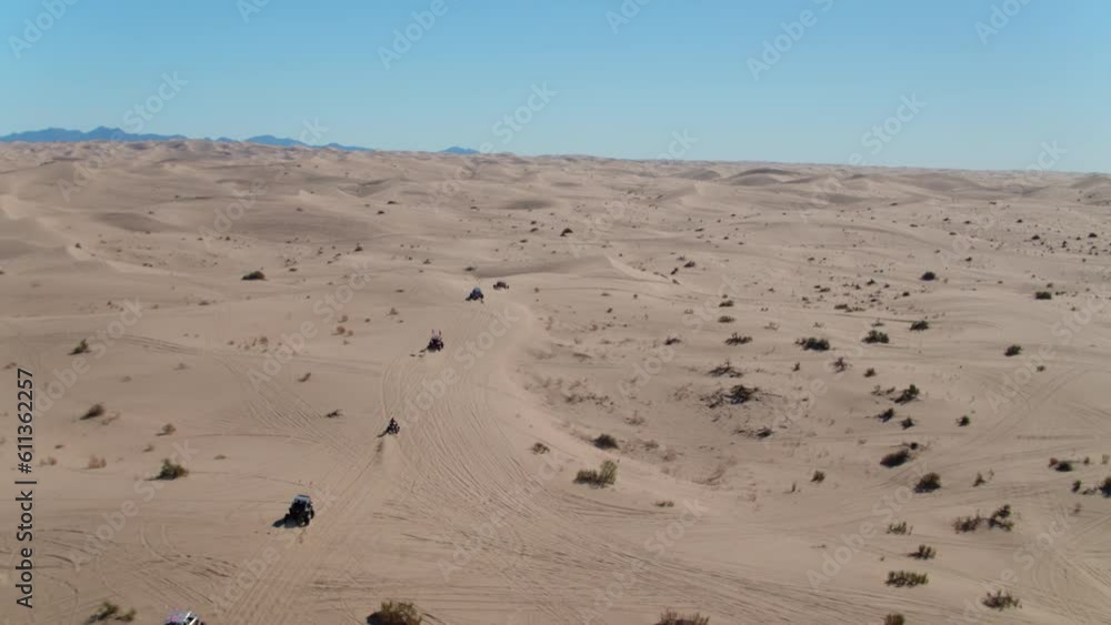 Aerial Shot Of Sandrails Amidst Bushes On Sand Dunes Against Sky, Drone Flying Forward Over Desert Landscape On Sunny Day - Glamis, California Aerial Shot Of Sandrails Amidst Bushes On Sand Dunes Against Sky, Drone Flying Forward Over Desert Landscape On Sunny Day - Glamis, California