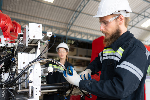 Foto Electrical engineer with the mission of installing a robot arm electrical system