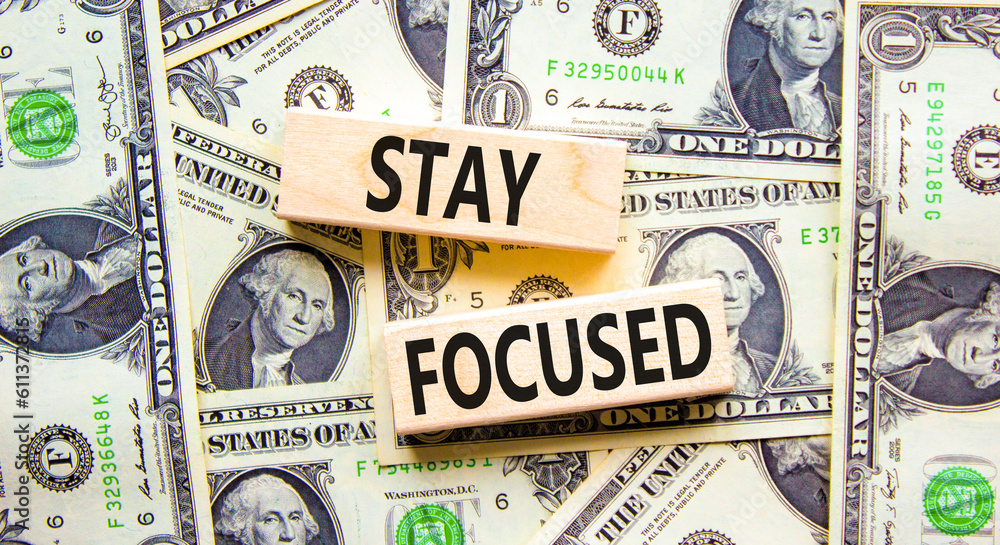 Stay focused symbol. Concept words Stay focused on wooden blocks on a beautiful background from dollar bills. Dollar bills. Business, support motivation psychological stay focused concept. Copy space.