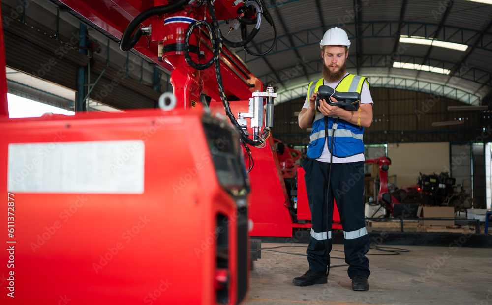 Fototapeta premium An engineers installing and testing a large robotic arm. before sending it to customers for use in the industry