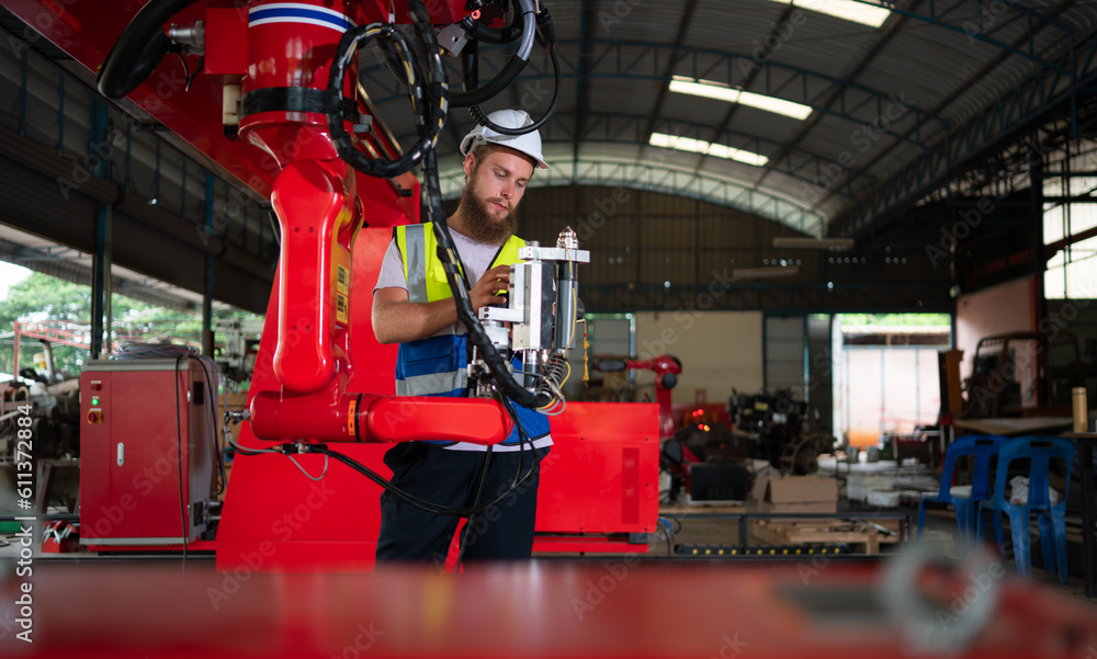 Naklejka premium An engineers installing and testing a large robotic arm. before sending it to customers for use in the industry