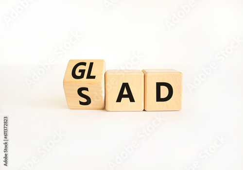 Glad or sad symbol. Businessman turns wooden cubes and changes the word Sad to Glad. Beautiful white table white background, copy space. Business and glad or sad concept.