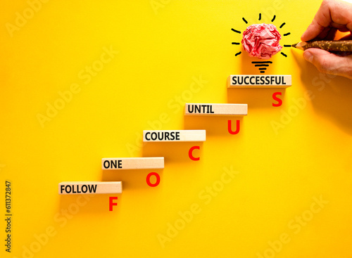 FOCUS follow one course until successful symbol. Concept words FOCUS follow one course until successful on wood block. Yellow background. Business FOCUS follow one course until successful concept.