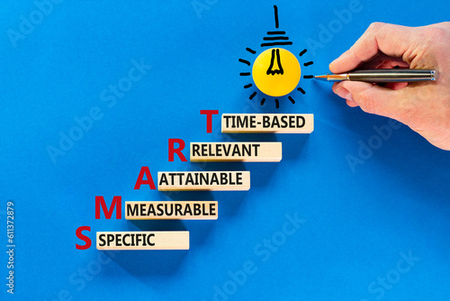 SMART symbol. Concept words SMART specific measurable attainable relevant time-based on block. Beautiful blue background. Business SMART specific measurable attainable relevant time-based concept.