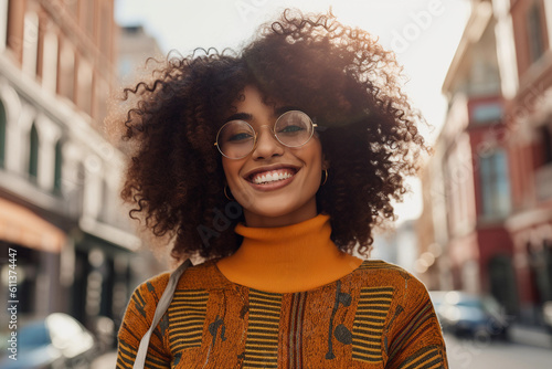 Generative AI illustration cheerful of young African American girl in glasses with curly hair looking at the camera standing on city street photo