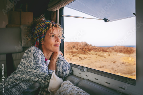 Happy oy woman tourist smiling and drinking view from inside her camper van. Vacation on renting vehicle motorhome concept lifestyle. Travel and summer happiness female people relaxing