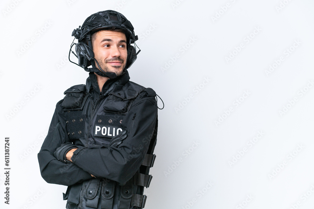 Young caucasian SWAT man isolated on white background with arms crossed and happy Young caucasian SWAT man isolated on white background with arms crossed and happy