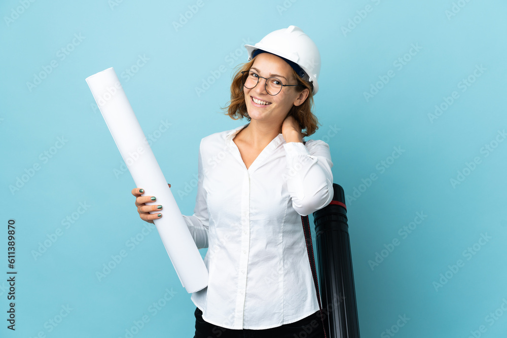 Young architect Georgian woman with helmet and holding blueprints over isolated background laughing Young architect Georgian woman with helmet and holding blueprints over isolated background laughing