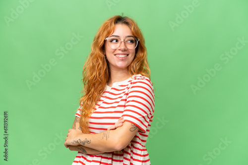 Young caucasian woman isolated on green screen chroma key background looking to the side and smiling © luismolinero