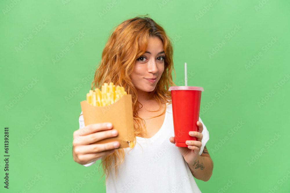 Young caucasian woman holding fried chips and soda isolated on green screen chroma key background background Young caucasian woman holding fried chips and soda isolated on green screen chroma key background background