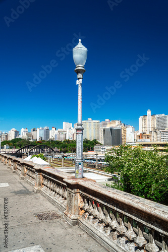 Light pole on Rua Sapucaí in Belo Horizonte. Viaduct Santa Teresa. Commercial and residential buildings. Beautiful blue sky. Vertical.