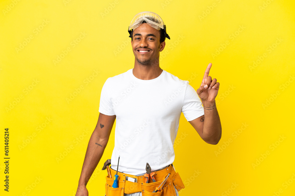 African American electrician man over isolated yellow wall showing and lifting a finger in sign of the best African American electrician man over isolated yellow wall showing and lifting a finger in sign of the best