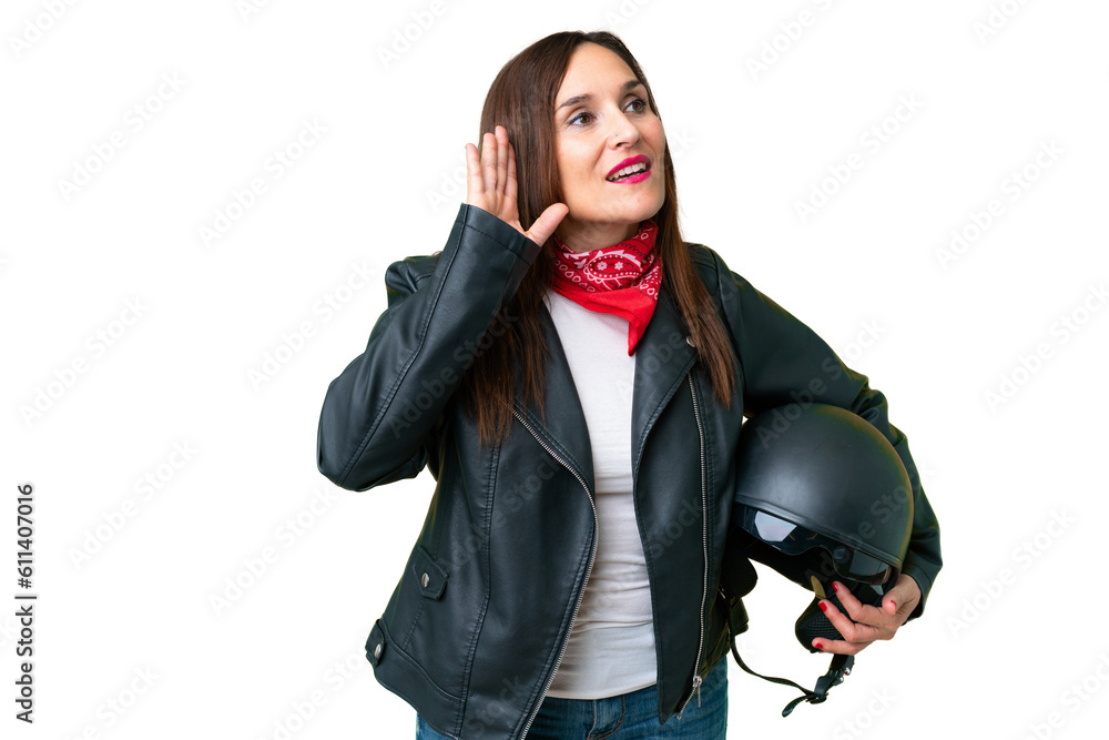 Middle age caucasian woman with a motorcycle helmet over isolated chroma key background listening to something by putting hand on the ear Middle age caucasian woman with a motorcycle helmet over isolated chroma key background listening to something by putting hand on the ear