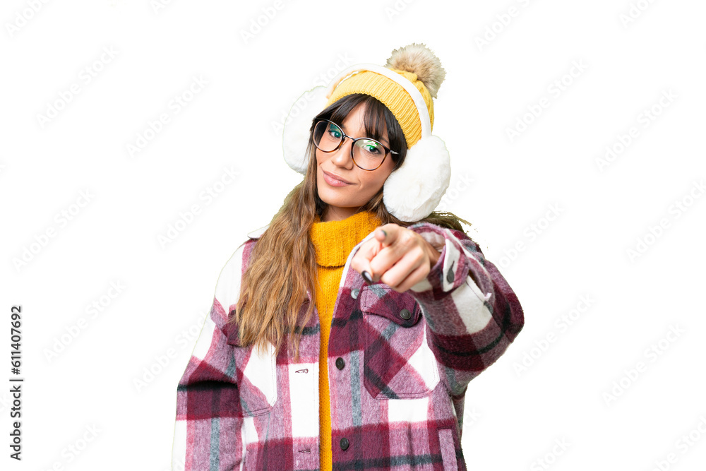 Young caucasian woman wearing winter muffs over isolated chroma key background points finger at you with a confident expression Young caucasian woman wearing winter muffs over isolated chroma key background points finger at you with a confident expression