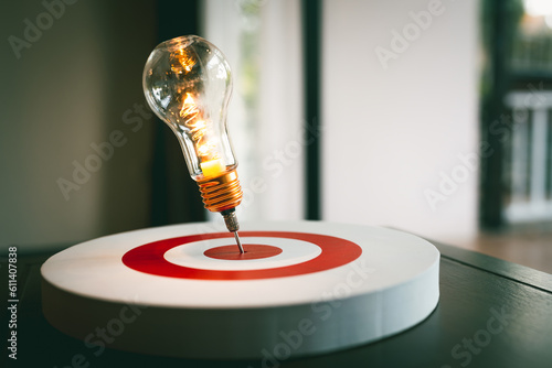 Light bulb with arrow of darts on dart board. Concept of finding problem solving or business development, key to success.	