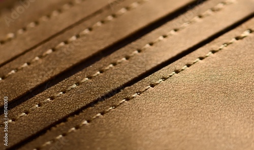 Handmade tan leather wallet, detail of the stitching. Close up, macro shot.