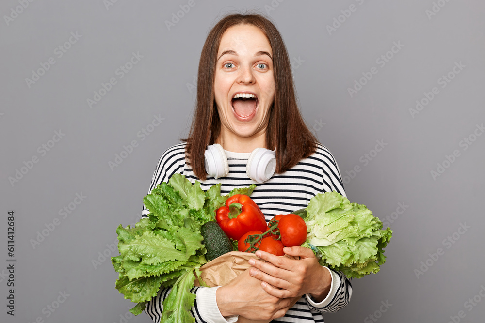 Green diet for healthy lifestyle. Fresh vegetables, nutrition powerhouse. Enjoy fresh salad daily. Nutritious fruits, essential vitamins. Excited woman holding vegetables isolated over gray background Green diet for healthy lifestyle. Fresh vegetables, nutrition powerhouse. Enjoy fresh salad daily. Nutritious fruits, essential vitamins. Excited woman holding vegetables isolated over gray background