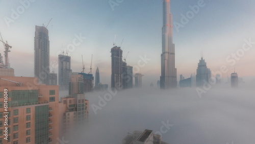 Aerial view of Dubai city early morning during fog night to day timelapse.