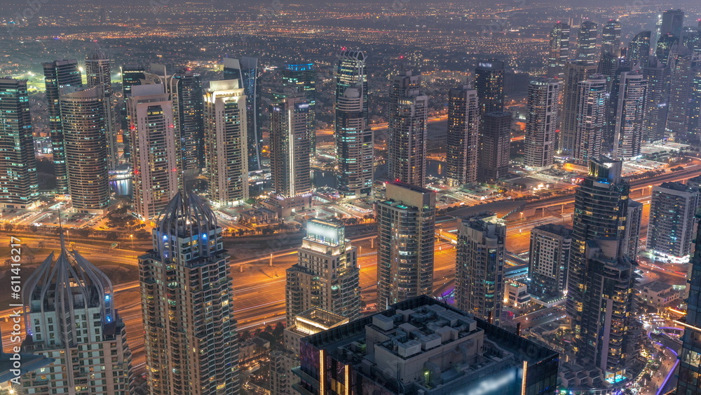 Obraz premium JLT and Dubai marina skyscrapers near Sheikh Zayed Road aerial day to night timelapse. Residential buildings