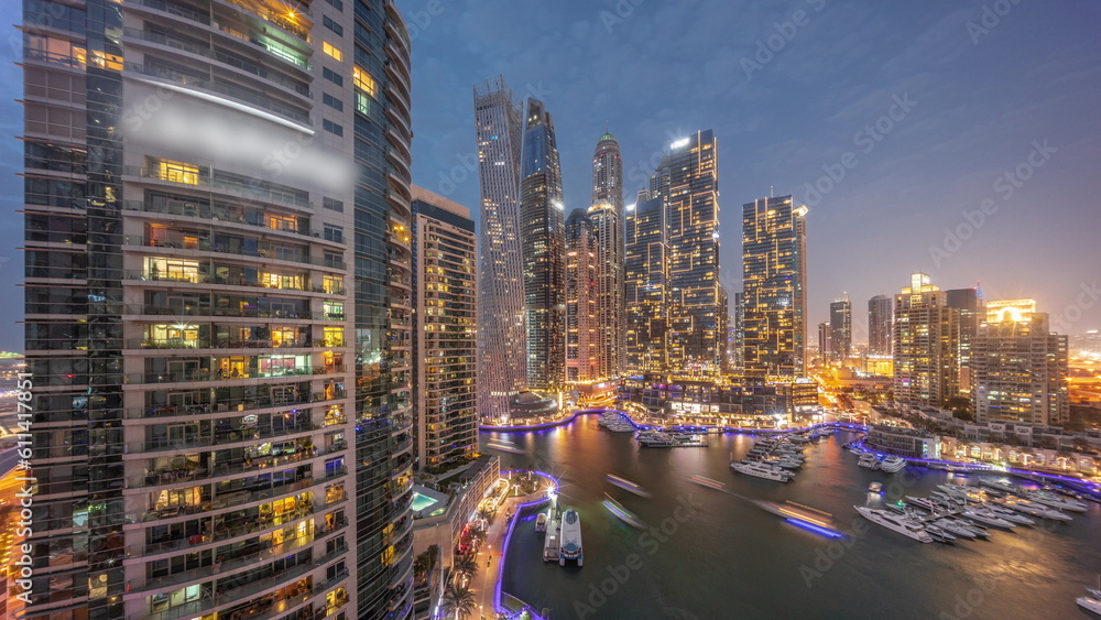 Obraz premium Dubai marina tallest skyscrapers and yachts in harbor aerial day to night timelapse.