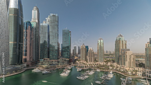 Panorama showing Dubai marina tallest skyscrapers and yachts in harbor aerial timelapse.