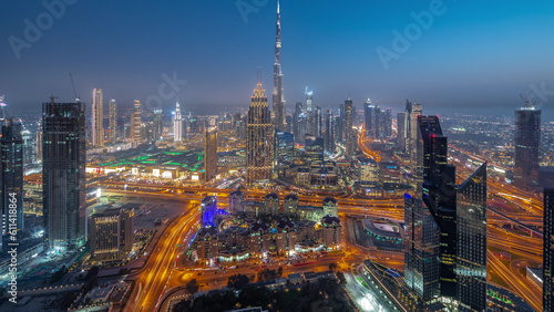 Aerial view of tallest towers in Dubai Downtown skyline and highway day to night timelapse.