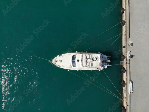 Aerial top view of white yacht on water at harbor, photo made by drone from above. Copy space