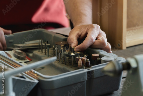Carpenter choosing mini drill tools on his toolbox