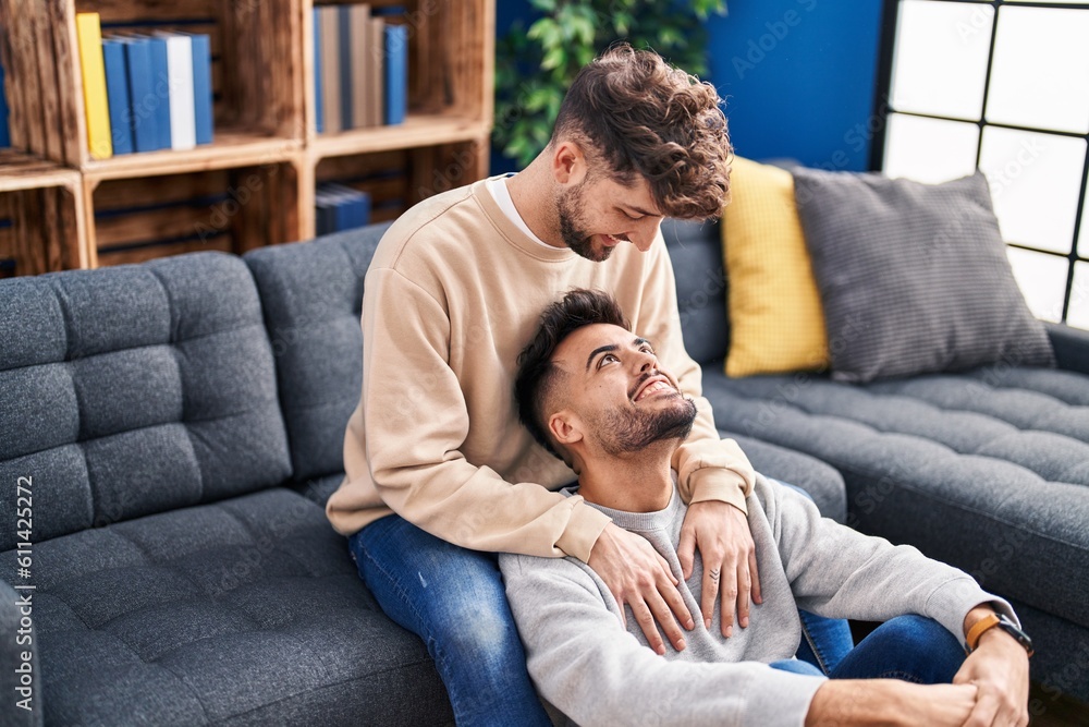 Young couple hugging each other sitting on sofa at home Young couple hugging each other sitting on sofa at home
