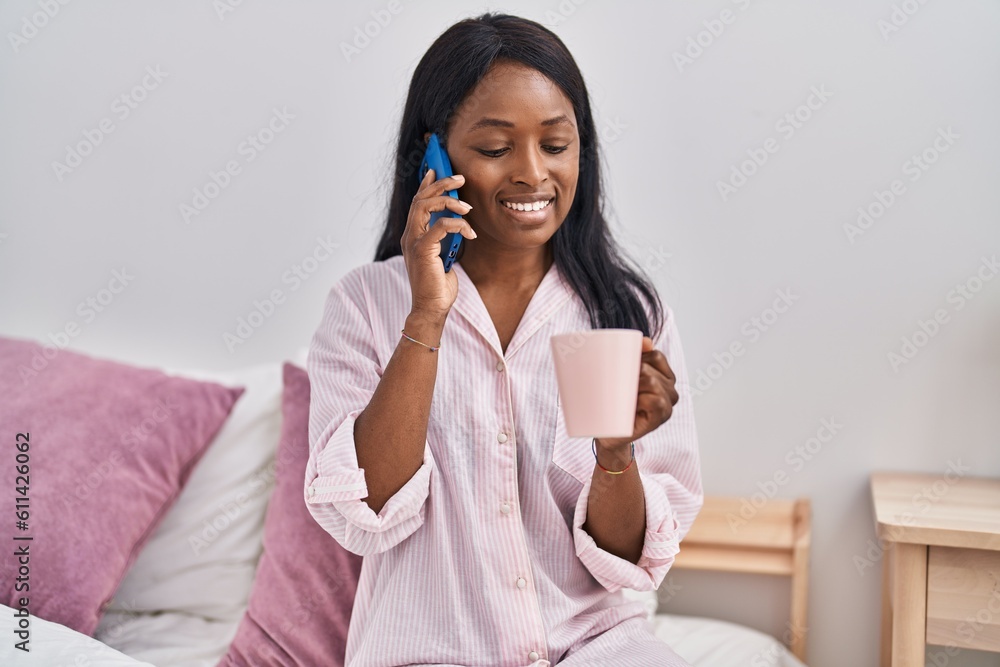 Young african american woman drinking coffee talking on the smartphone at bedroom Young african american woman drinking coffee talking on the smartphone at bedroom