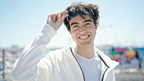 Young hispanic man smiling confident wearing sunglasses at seaside