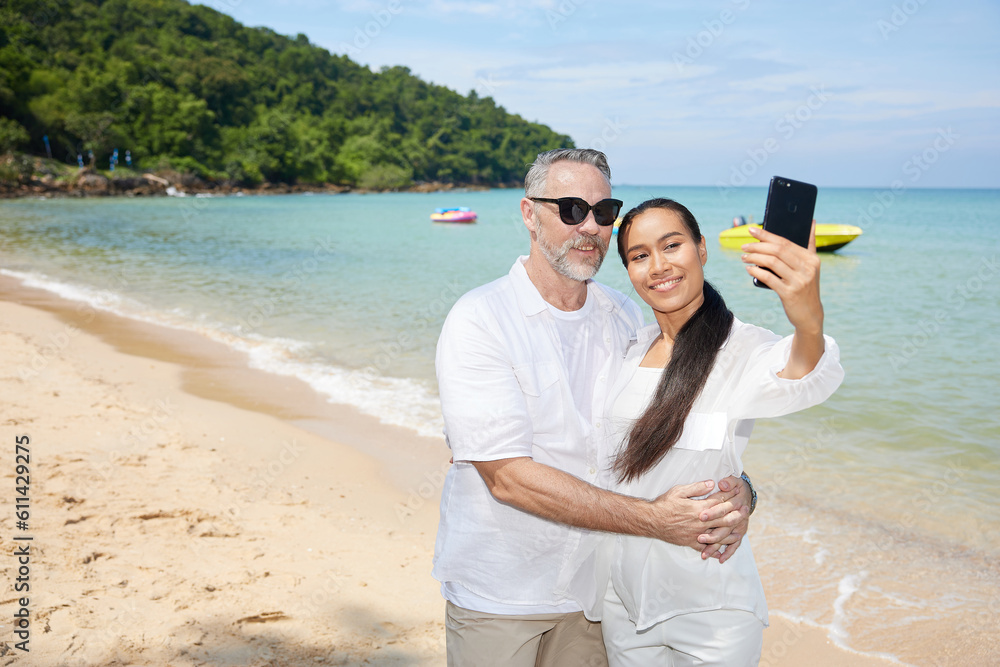 couple taking a selfie by smartphone on the beach