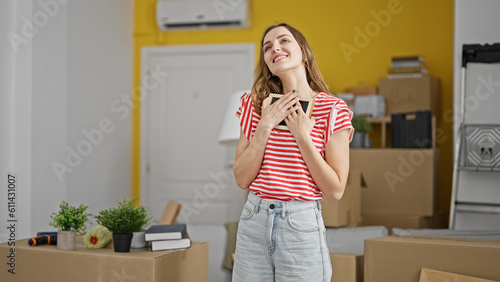 Young blonde woman smiling confident hugging photo at new home © Krakenimages.com