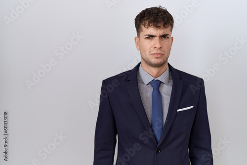 Young hispanic business man wearing suit and tie skeptic and nervous, frowning upset because of problem. negative person.