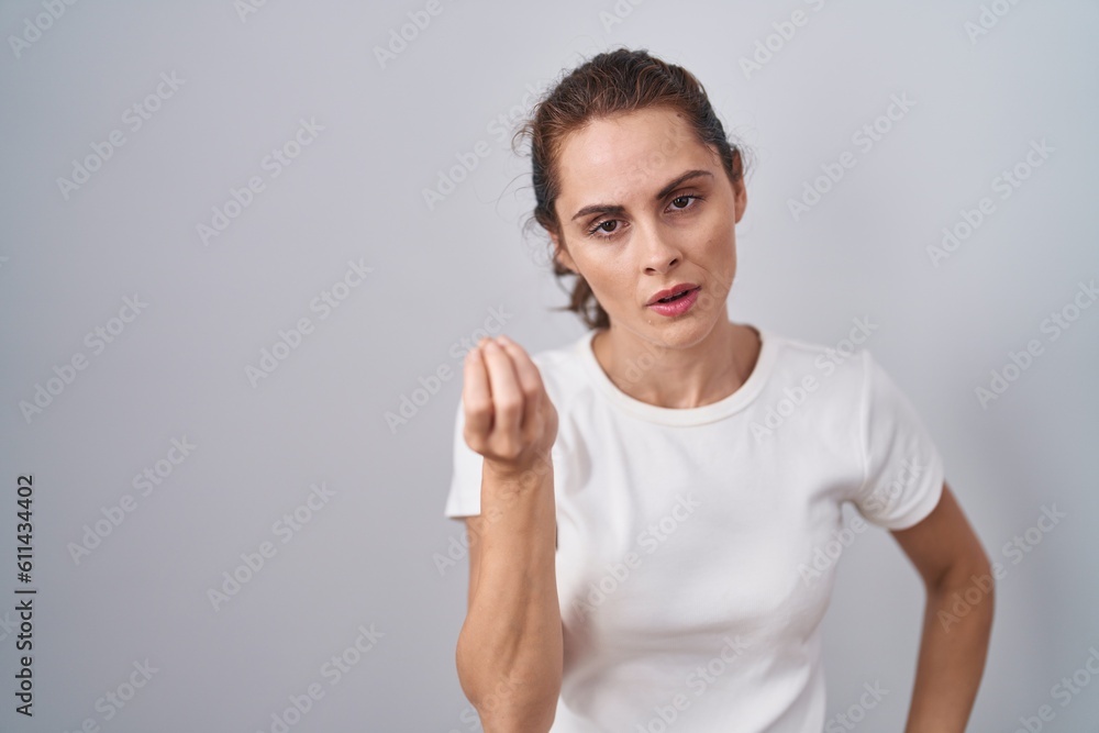 Beautiful brunette woman standing over isolated background doing italian gesture with hand and fingers confident expression Beautiful brunette woman standing over isolated background doing italian gesture with hand and fingers confident expression