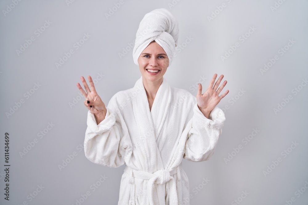 Blonde caucasian woman wearing bathrobe showing and pointing up with fingers number eight while smiling confident and happy. Blonde caucasian woman wearing bathrobe showing and pointing up with fingers number eight while smiling confident and happy.