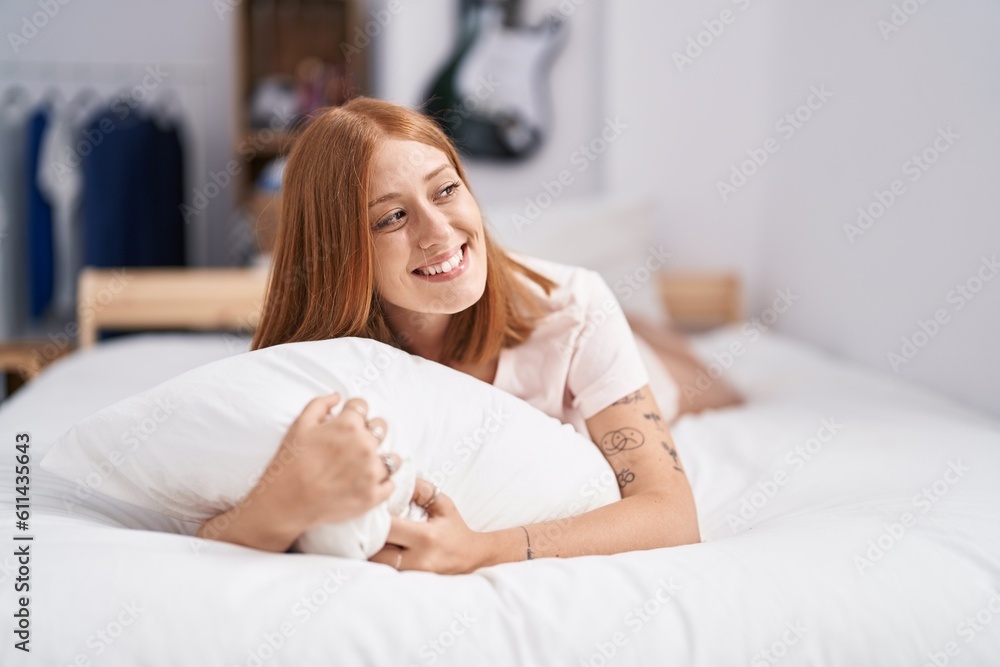 Young redhead woman lying on bed hugging pillow at bedroom Young redhead woman lying on bed hugging pillow at bedroom