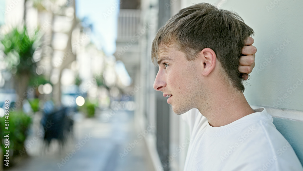 Young caucasian man looking to the side with serious expression at street Young caucasian man looking to the side with serious expression at street