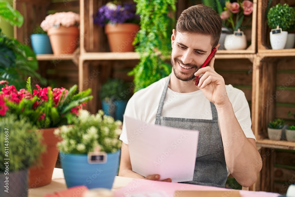 Young caucasian man florist talking on smartphone reading document at flower shop Young caucasian man florist talking on smartphone reading document at flower shop