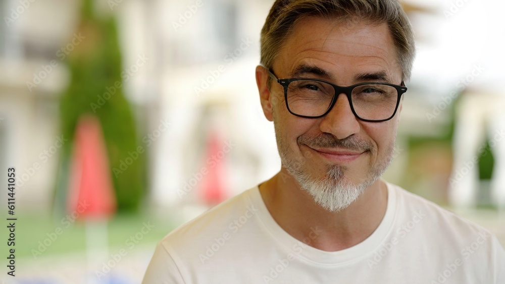 Portrait of happy middle aged man at home in front of house, confident, smiling. Outdoor in garden of villa, residence. Portrait of happy middle aged man at home in front of house, confident, smiling. Outdoor in garden of villa, residence.